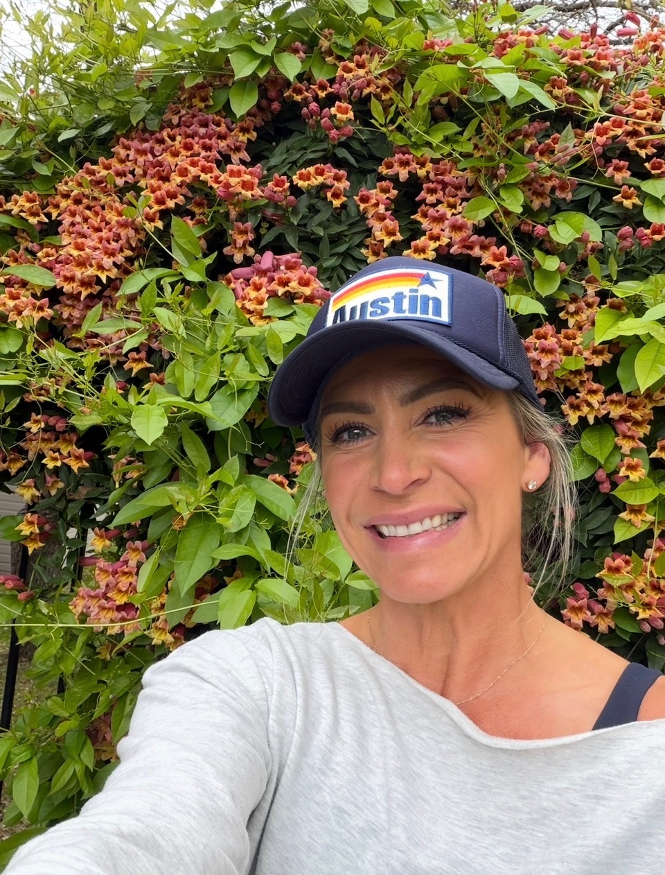 April Stiles photographed in front of flowering plants