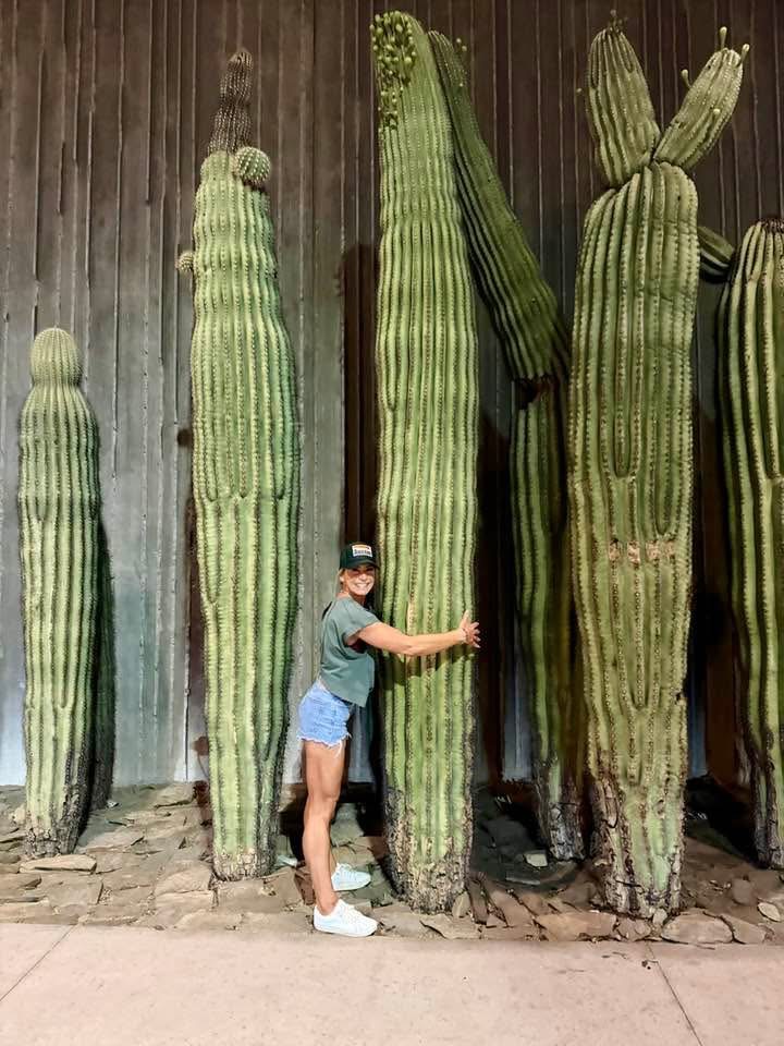 April Stiles standing beside giant cacti